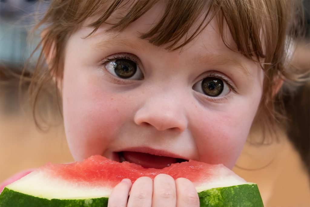 small girl eating watermelon